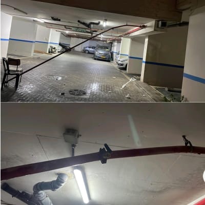 חניון תת קרקעי עם צינורות תלויים מהתקרה