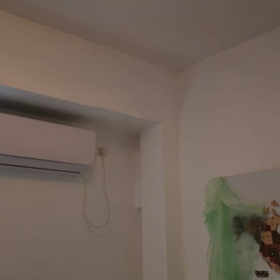 מזגן מותקן על קיר עם כבל חשמל תלוי