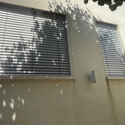 חלונות עם רשתות למניעת יונים על קיר חיצוני