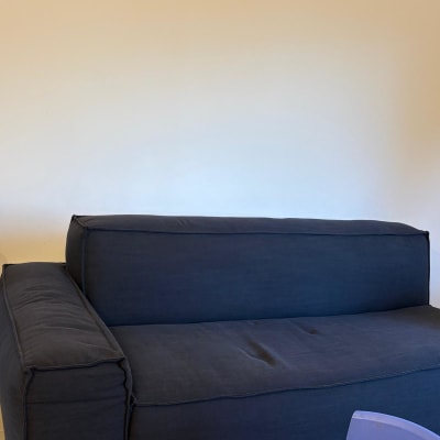 ספה כחולה בחדר עם קיר לבן