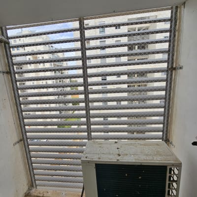 רשת מתכת על חלון למניעת כניסת יונים