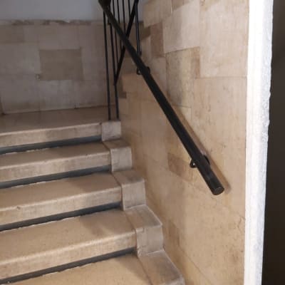 מעקה מתכת שחור על קיר מדרגות אבן