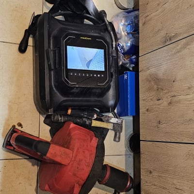 כלי עבודה של אינסטלטור על רצפה, כולל מצלמה וצינור