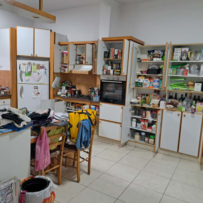 מטבח מבולגן עם ארונות פתוחים ומוצרים שונים