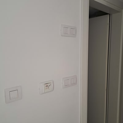 קיר לבן עם מתגי חשמל ותרמוסטט