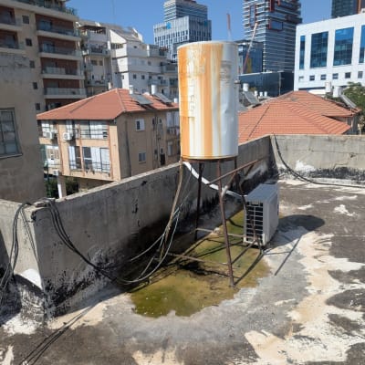 דוד שמש על גג עם חלודה וצנרת חשופה