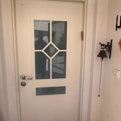 דלת לבנה עם חלונות זכוכית ועיטור מתכת