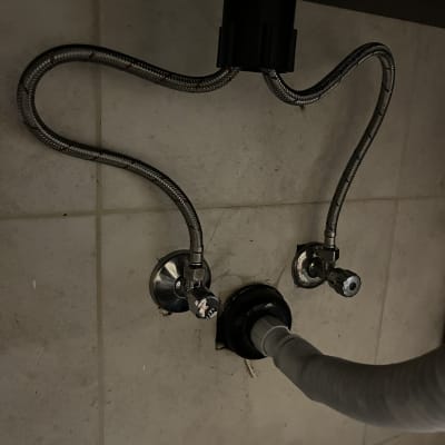 צינורות מתכת וברזים מתחת לכיור