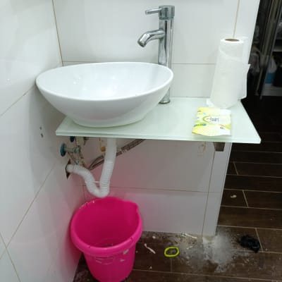 כיור עם ברז, דלי ורוד וצינור ניקוז