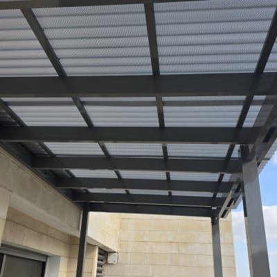 פרגולת אלומיניום אפורה במרפסת עם קירוי סנטף BH שקוף