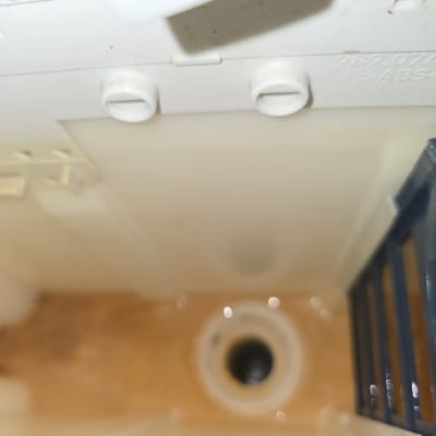 תמונה של פנים מיכל שירותים עם צינור וניקוז
