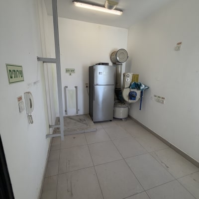 חדר עם מקרר וציוד ניקוי, מתאים לפינוי בית