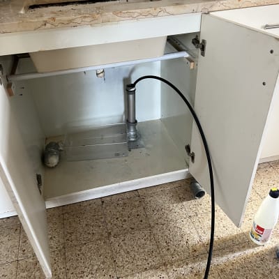 כיור מטבח פתוח עם צינור ניקוז וכלים לניקוי