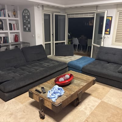 ספה כהה עם מגבת כחולה על שולחן עץ