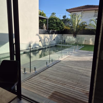 גדר זכוכית סביב בריכה בחצר בית