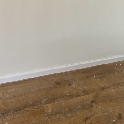 רצפת פרקט עץ חום עם לוח קיר לבן