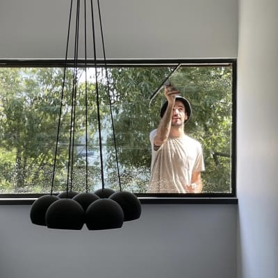 אדם מנקה חלון מבחוץ עם מגב