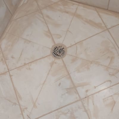 רצפת מקלחת עם ניקוז מרכזי ואריחים מלוכלכים