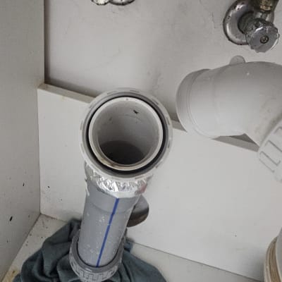 צנרת מתחת לכיור עם ברזים וצינור