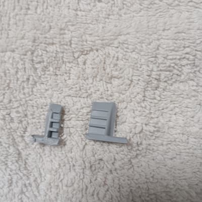 שני חלקי פלסטיק אפורים על רקע בד לבן