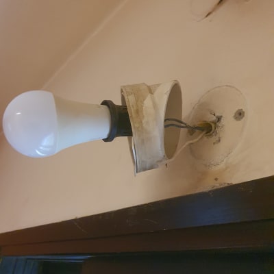 מנורה מותקנת על קיר עם חוטים חשופים