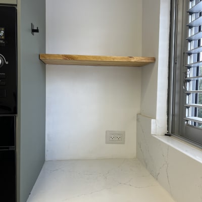 מדף עץ מעל משטח שיש במטבח