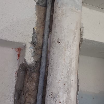 צינור מתכת בקיר עם טיח מתקלף