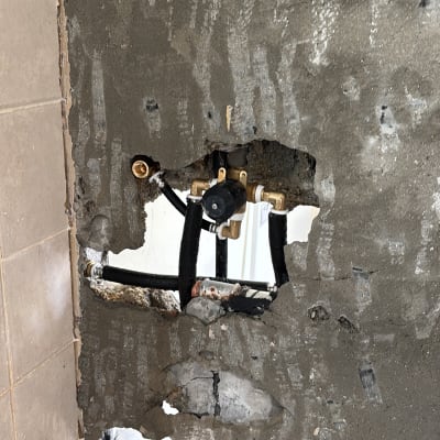 צנרת חשופה בקיר עם חיבורים ותשתית אינסטלציה