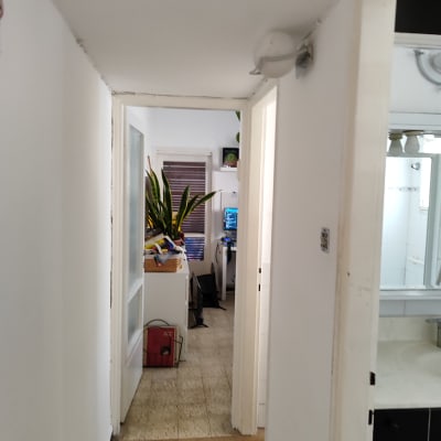 מסדרון עם קירות צבועים בלבן ודלתות פתוחות