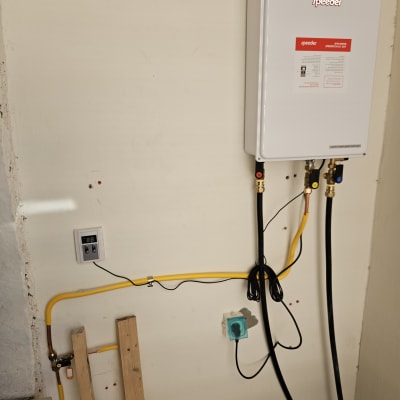 מחמם מים גז מחובר לצינורות וקופסת חשמל