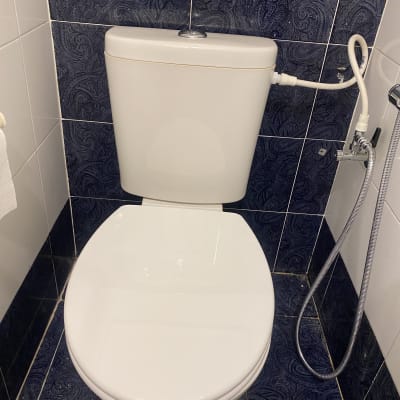 אסלה עם מיכל הדחה וצינור מים