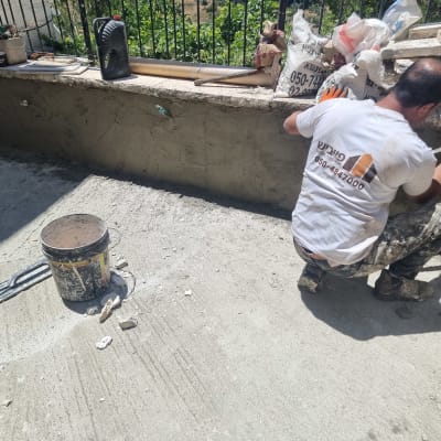 אדם עובד על איטום קיר עם כלים וחומרים