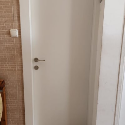 דלת לבנה עם ידית מתכת בחדר פנימי