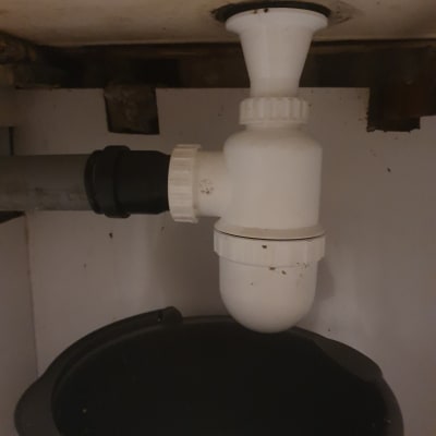 צנרת מתחת לכיור עם דלי