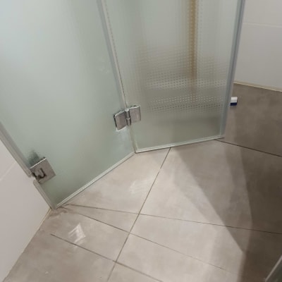 דלתות זכוכית במקלחת עם רצפת אריחים