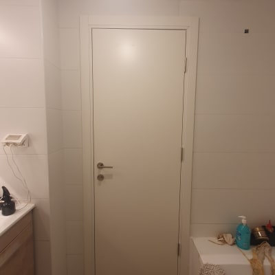 דלת לבנה עם ידית מתכת בחדר אמבטיה