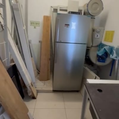 חדר עם מקרר, לוחות עץ וכלים שונים