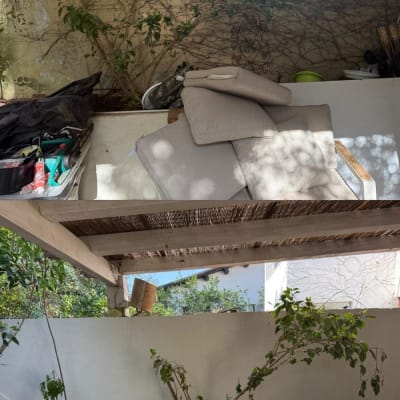 מרפסת עם צמחים וריהוט גן תחת פרגולה.