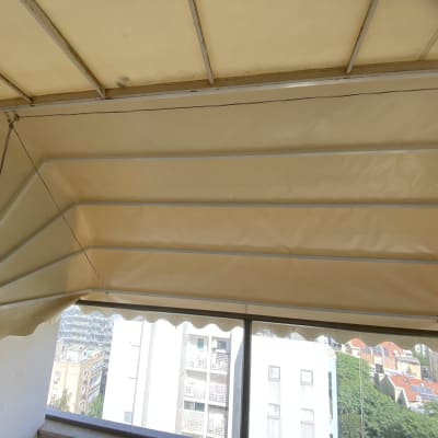 סוכך בד מתוח על מסגרת מתכת במרפסת