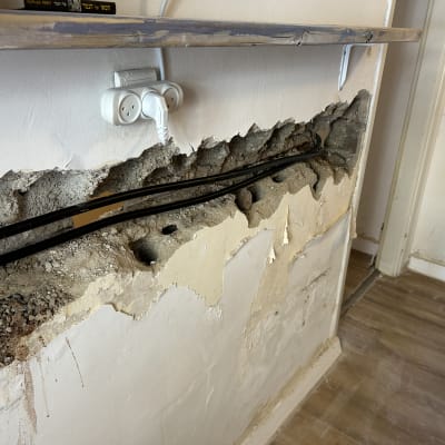 קיר פתוח עם צינורות חשמל חשופים