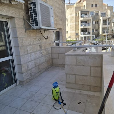 מרפסת עם מזגן ומיכל ריסוס על הרצפה