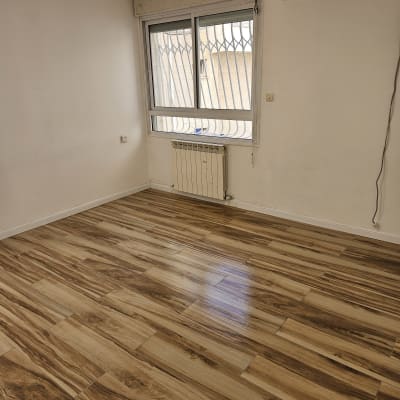 חדר ריק עם רצפת עץ נקייה ומזגן על הקיר