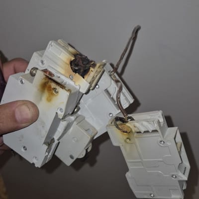 חוטים שרופים וממסר חשמלי פגום ביד חשמלאי