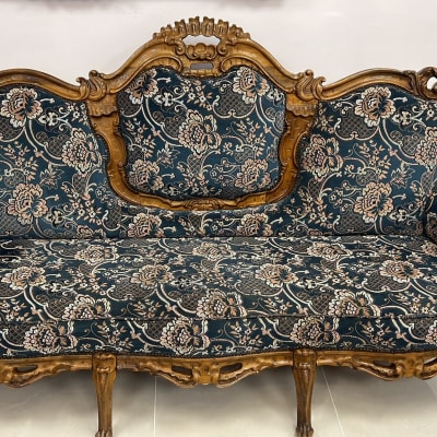 ספה מעוצבת עם ריפוד פרחוני ועץ מגולף