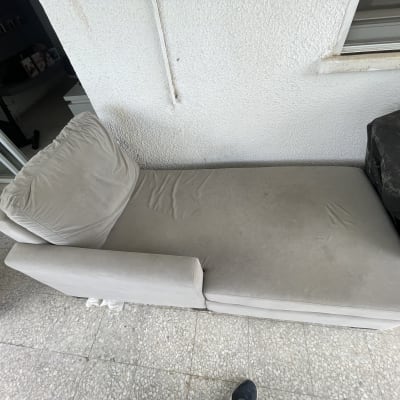 ספה אפורה עם כתמים על המרפסת