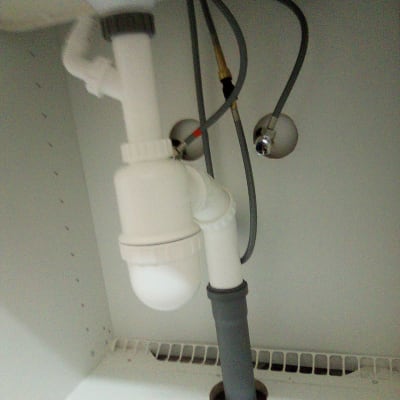 צנרת פלסטיק מתחת לכיור עם חיבורים