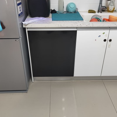 מטבח עם כיור, כלים, מקרר וארונות לבנים