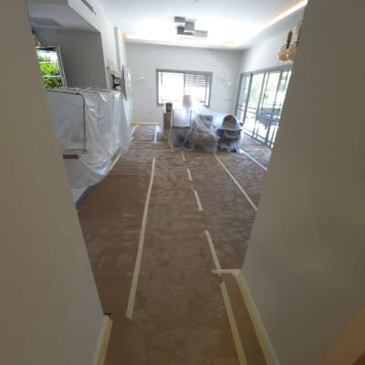 חדר עם רהיטים מכוסים בניילון לקראת צביעה