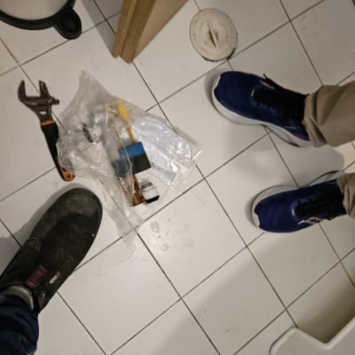 כלי עבודה של אינסטלטור על רצפת חדר אמבטיה