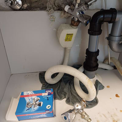 כלי עבודה וצינורות מתחת לכיור